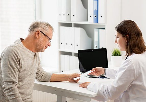 senior man and doctor meeting at hospital medicine, age, health care and people concept - senior man and doctor with prescription meeting in medical office at hospital