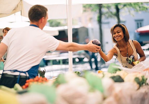 Young woman buying vegetables at farmers market Young woman buying vegetables at farmers market