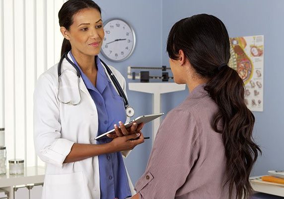 African American gynecologist talking to patient with tablet African American gynecologist talking to patient with tablet
